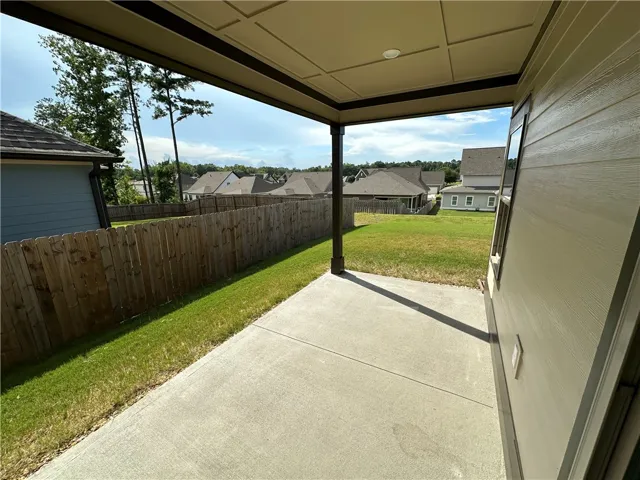An inviting covered patio offers a private outdoor retreat with ample space for relaxation.