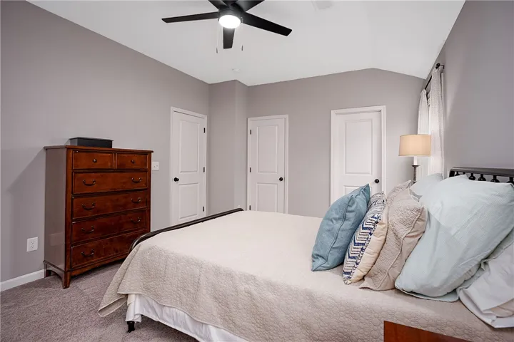 Sloping ceilings and a ceiling fan create an airy, comfortable sleeping space.