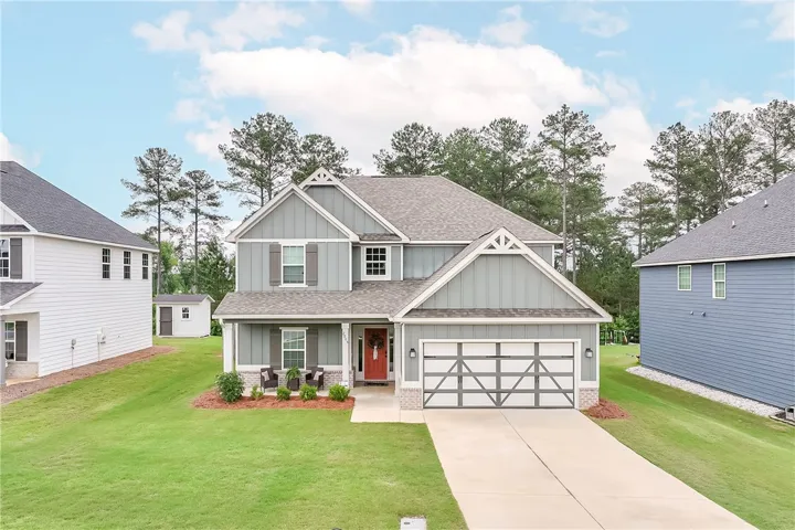 A welcoming front porch and attached garage define this charming two-story residence.