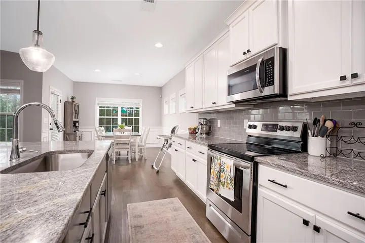 Granite counters and stainless steel appliances adorn this generous, open-concept kitchen.