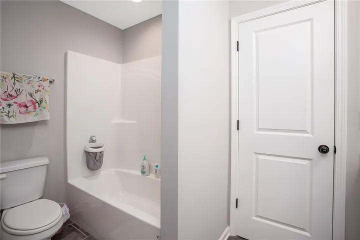 Tiled flooring and a practical shower-tub combination characterize this well-appointed bathroom.