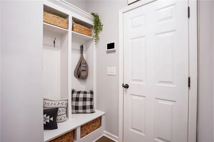 A well-organized entryway features built-in storage with a convenient bench and overhead shelving.