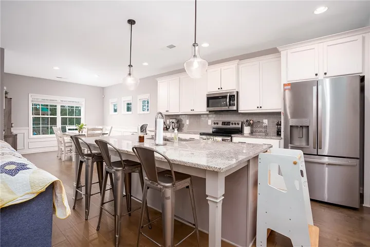 A well-appointed kitchen island with pendant lighting anchors this inviting, open-concept living space.
