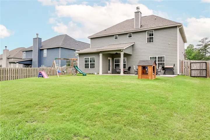 A spacious yard perfect for entertaining features a covered patio and a separate open-air space.