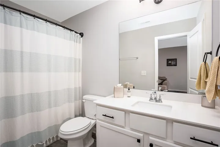 White vanity with clean lines provides ample storage in this well-appointed bathroom.
