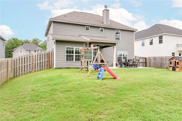 A spacious backyard with a generous patio and private fencing provides ample room for outdoor enjoyment.