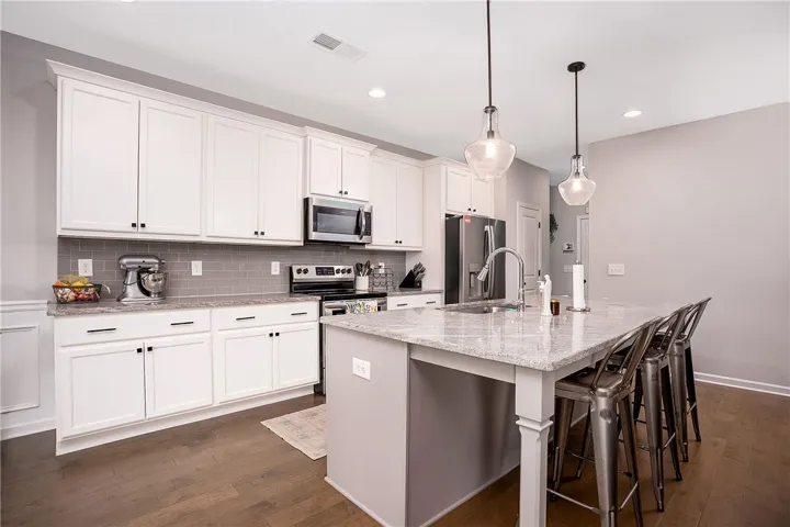 Culinary creations come to life in this kitchen, featuring an inviting island and elegant granite counters.