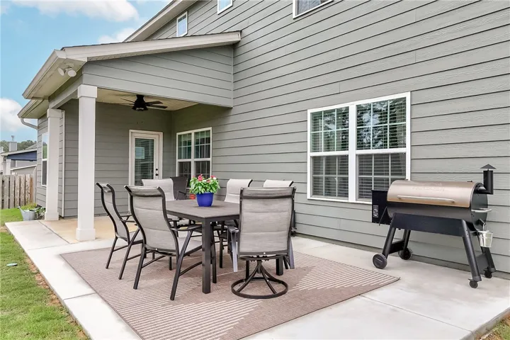 An inviting covered patio with ceiling fan extends living space outdoors for leisure and dining.