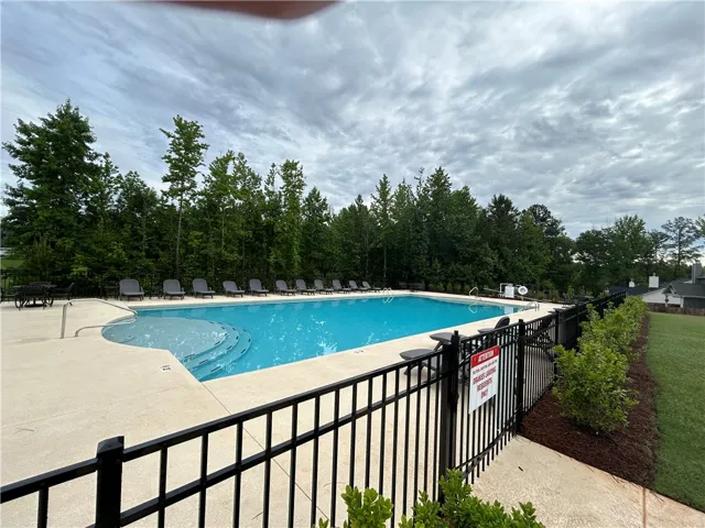 Lush landscaping surrounds this crystal-clear community pool, perfect for leisure under open skies.