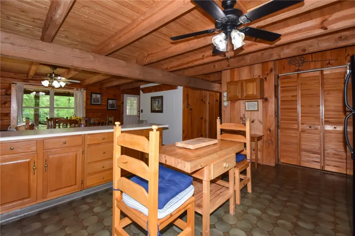 A well-lit kitchen with natural wood walls and ceiling beams, creating a cozy atmosphere.