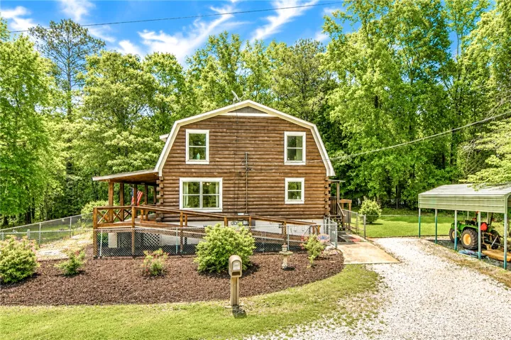 A charming log home nestled amidst verdant trees offers a tranquil retreat.