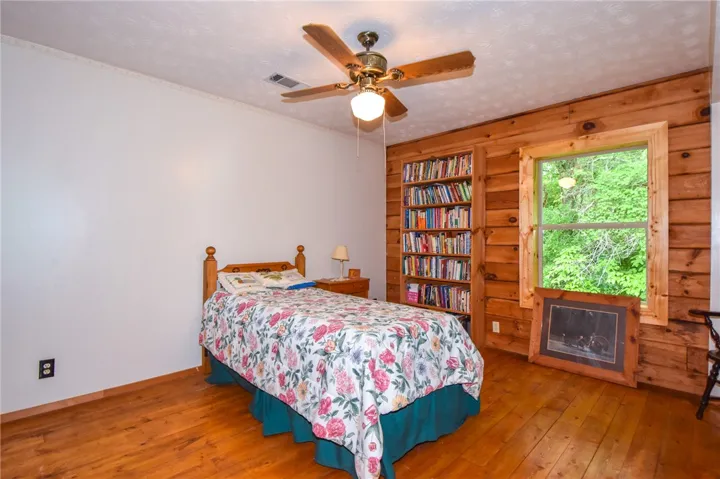 A cozy retreat with natural wood paneling and extensive built-in shelving for a personal library.