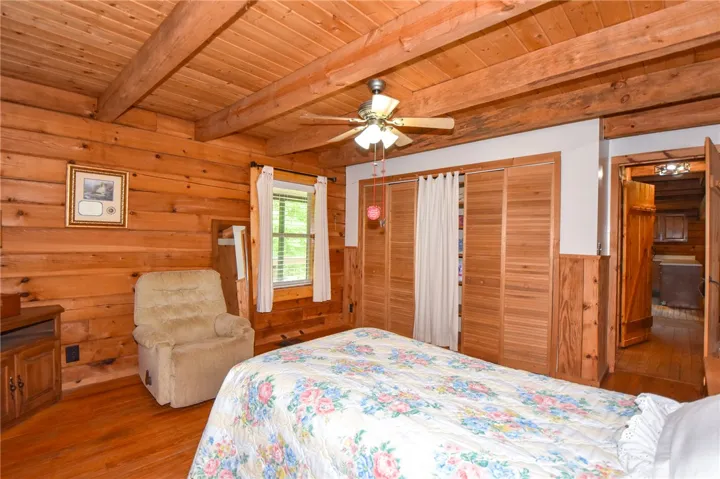 Authentic wood-paneled walls and ceiling beams create a warm, inviting bedroom retreat.
