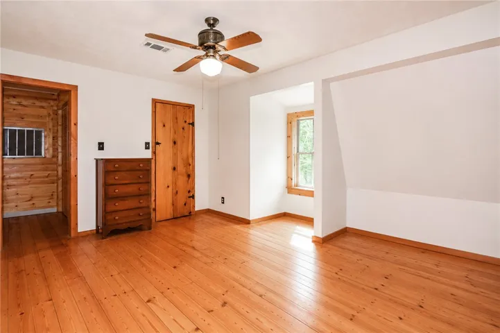 Well-lit living area with polished hardwood floors and natural wood accents throughout.