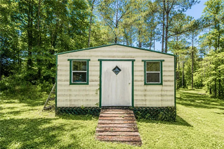 A quaint shed amidst verdant trees offers a secluded retreat.