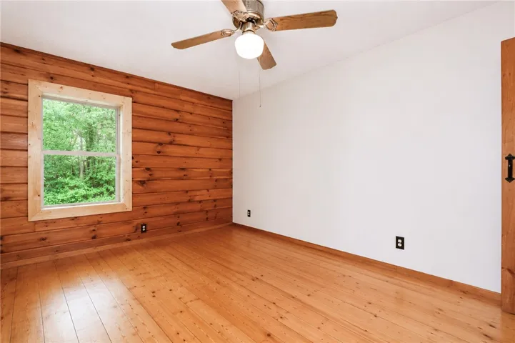 Natural wood paneling and wide plank flooring combine to create a warm and inviting atmosphere.