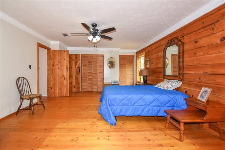 Natural wood paneling and vibrant flooring distinguish this rustic yet welcoming bedroom retreat.