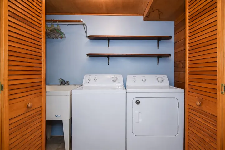 A dedicated laundry space, neatly concealed behind louvered doors, offers essential convenience.