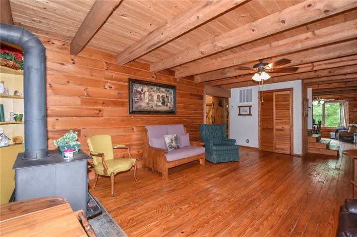 A cabin-inspired living area showcases exposed wood beams and broad plank flooring.