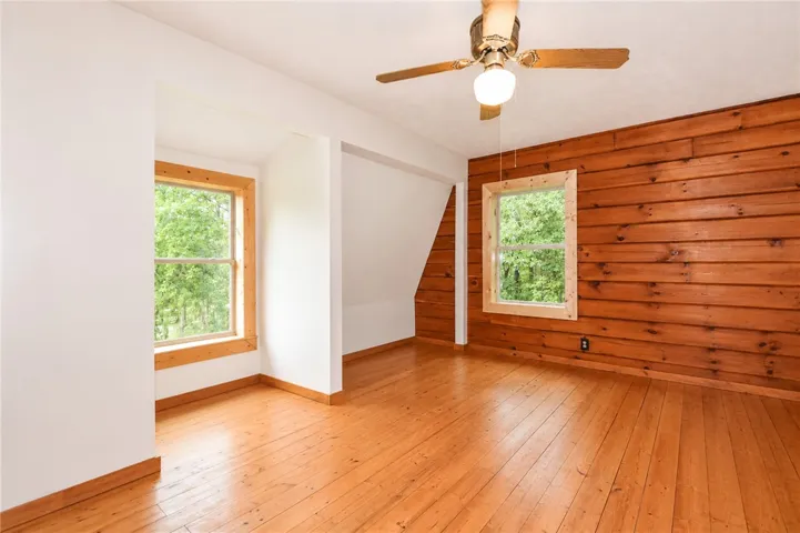 Natural wood paneling and clear-finished hardwood flooring define this comfortable room.