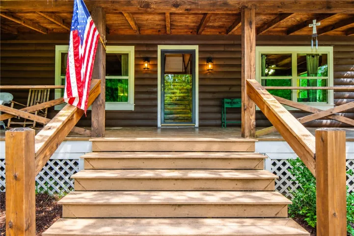 A welcoming front porch with rustic log siding invites entry into this charming home.