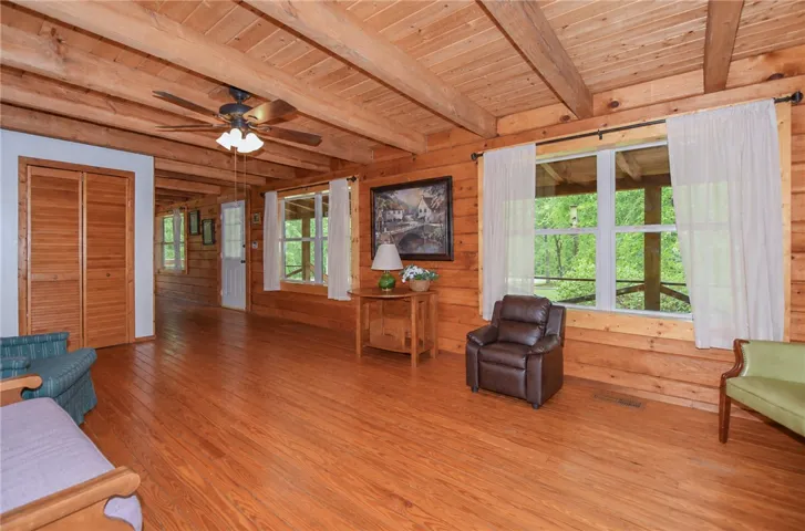Natural wood floors and ceilings create a warm, inviting atmosphere in this spacious living area.