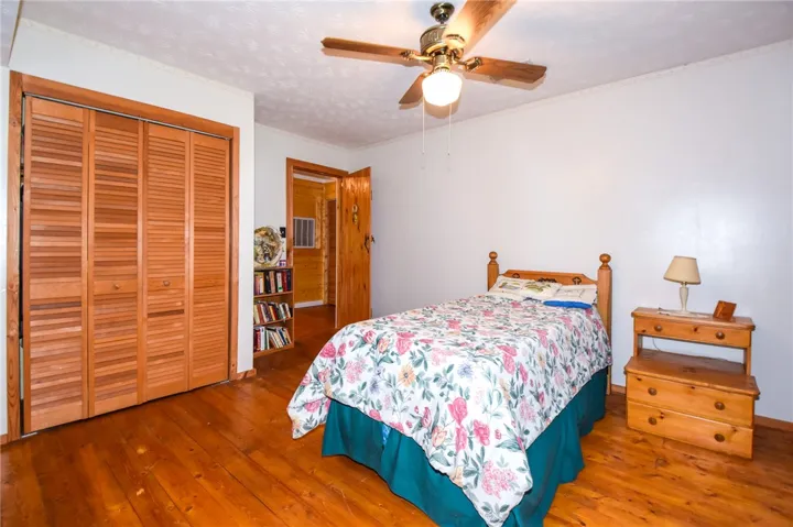Rich hardwood flooring creates a cozy ambiance in this inviting bedroom retreat.