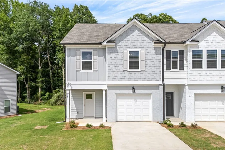 A contemporary townhome with a light-toned exterior and attached garage offers a seamless blend of style and convenience.