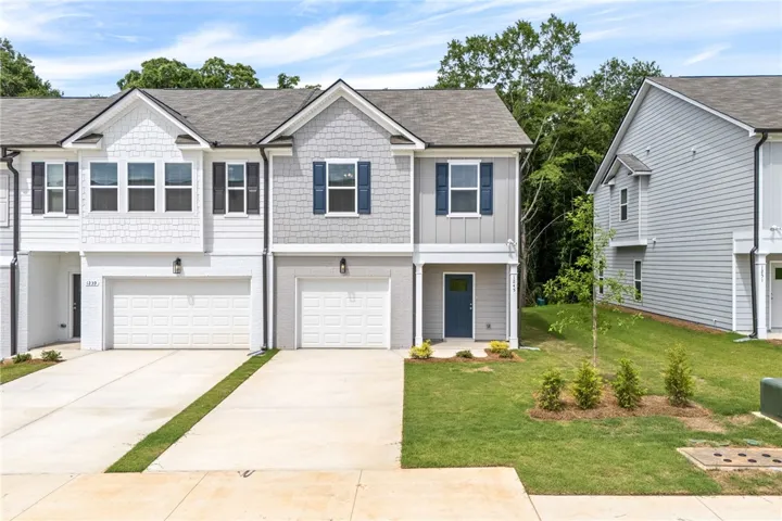 These modern townhomes feature individual garages and inviting front entrances, framed by manicured lawns.