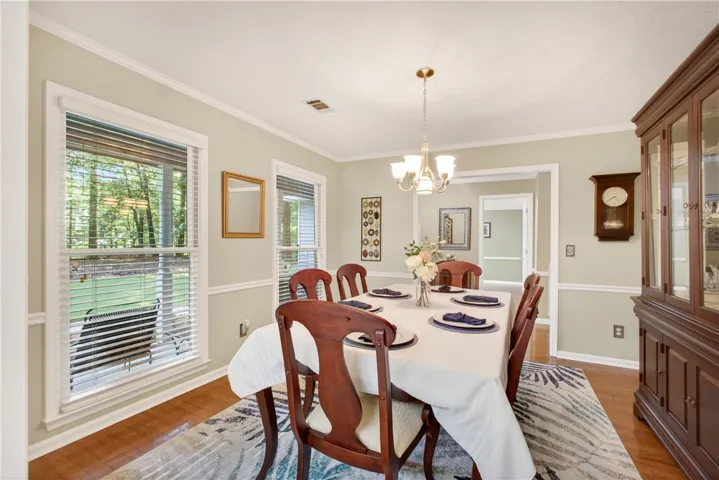 Elegant crown molding and rich hardwood floors define this inviting dining area.