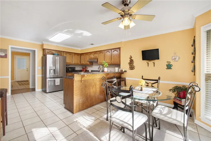 A well-lit kitchen with classic wooden cabinetry and a comfortable breakfast bar offers casual dining.
