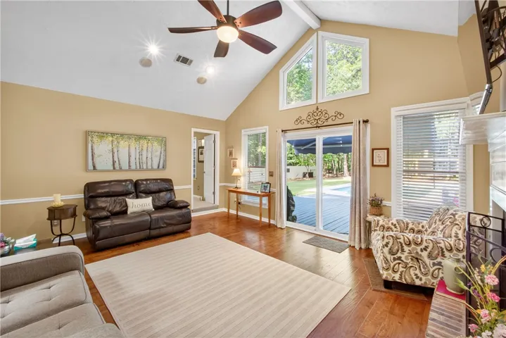 Hardwood floors and a vaulted ceiling elevate this sun-filled living area.