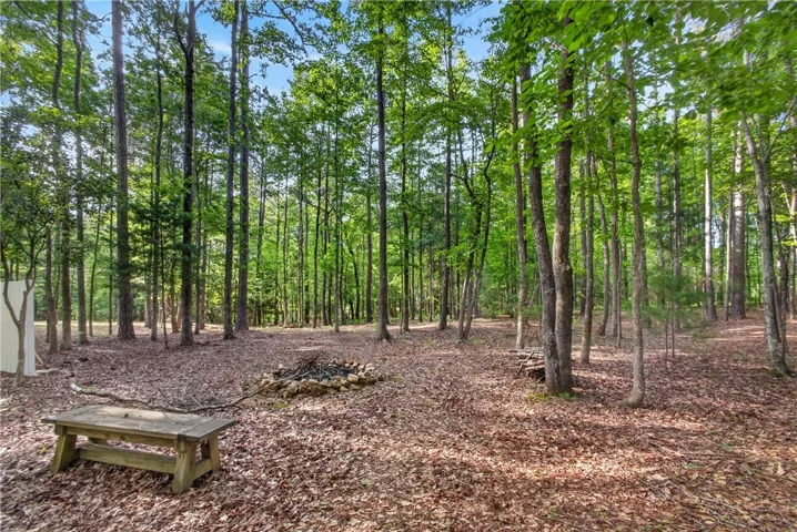A tranquil wooded haven awaits, complete with a natural fire pit area.