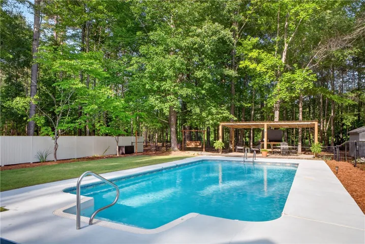 An inviting backyard oasis offers a sparkling in-ground pool and an extensive covered patio.