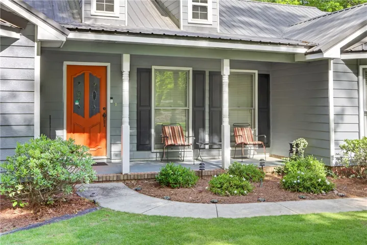 A welcoming front porch with classic columns invites entry, framed by established landscaping.