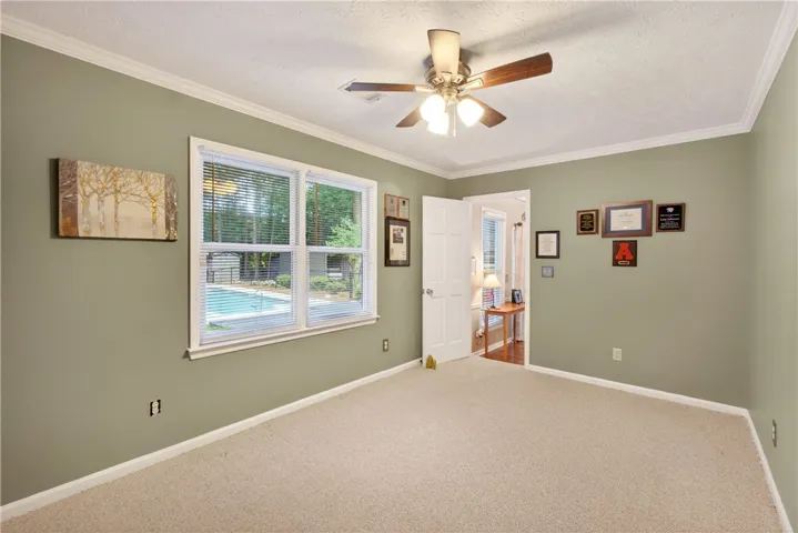 A window in this sun-filled bedroom offers refreshing views of the private pool.