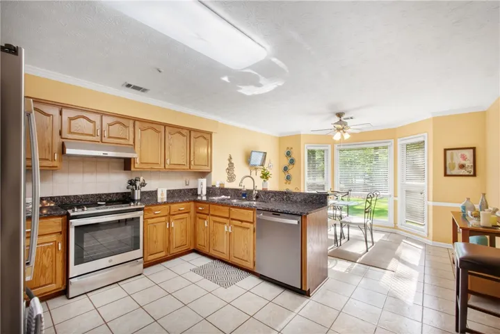 A well-equipped kitchen features a bay window with natural illumination, perfect for a cozy dining nook.