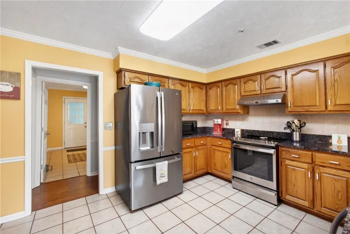 A classic kitchen with durable tile flooring and well-maintained wooden cabinetry.