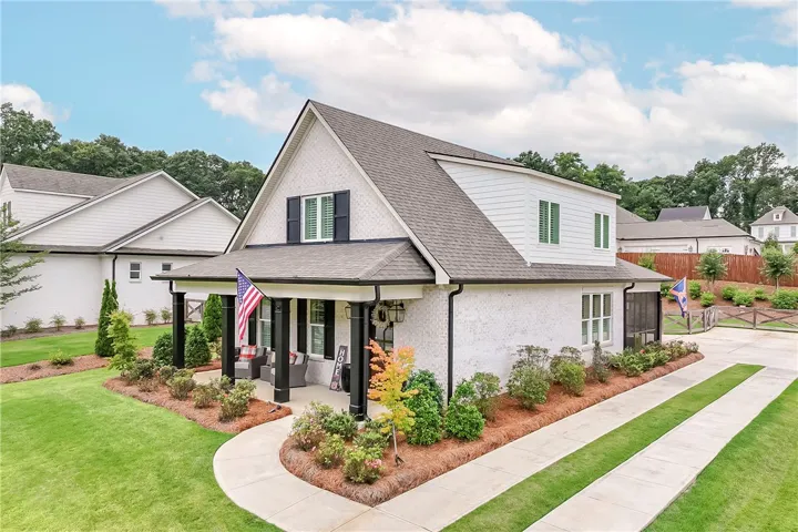 A graceful home featuring a welcoming front porch and well-manicured landscaping.