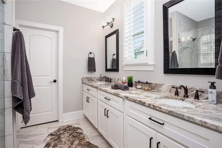 Dual vanities with stone counters and modern fixtures define this well-appointed bath.