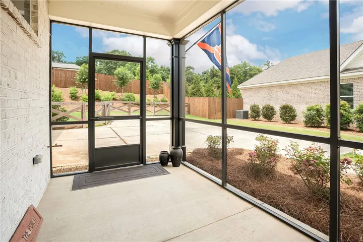 Relax and enjoy outdoor moments on this comfortable screened porch overlooking a well-maintained yard.