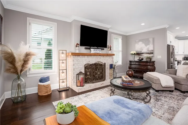 Hardwood floors and a white brick fireplace anchor this welcoming living area.