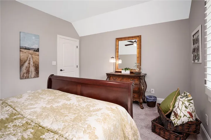 Sloping ceilings and soft gray walls create a comfortable, airy atmosphere in this inviting bedroom.