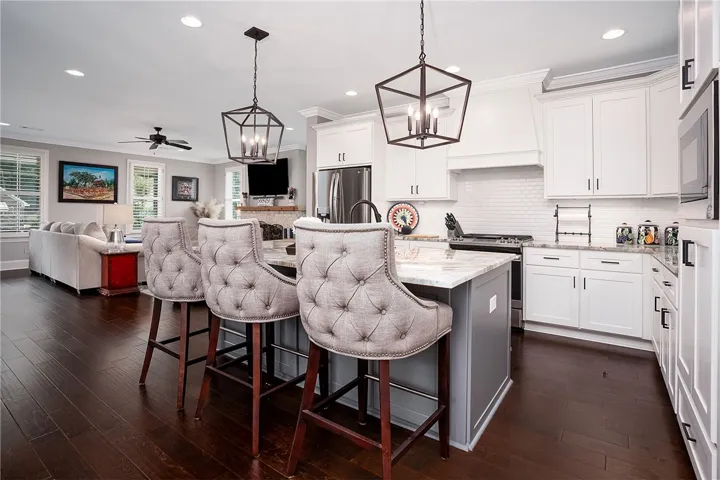 A gourmet kitchen with an inviting island and elegant fixtures blends seamlessly into the living space, perfect for entertaining.