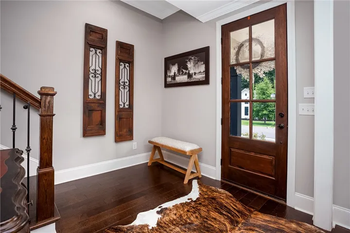 Rich hardwood flooring greets you upon entering this inviting home through a stylish front door.