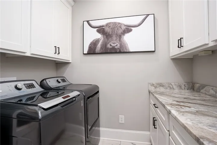 Utility space with sleek appliances and  granite countertops.