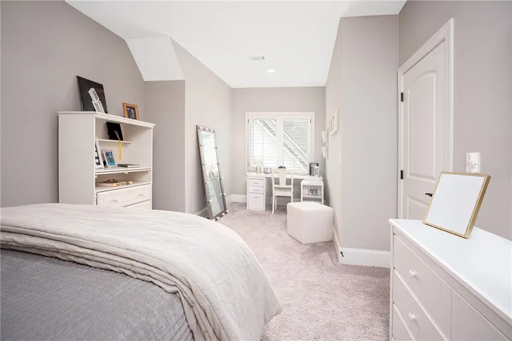 An inviting sleeping space with gently sloped ceilings and ample natural light.