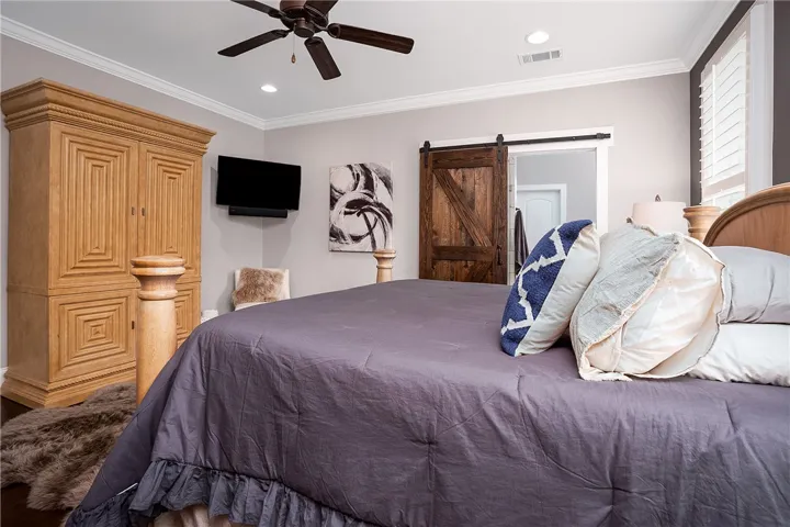 Relax in a generously proportioned bedroom offering rich wood tones and natural light.