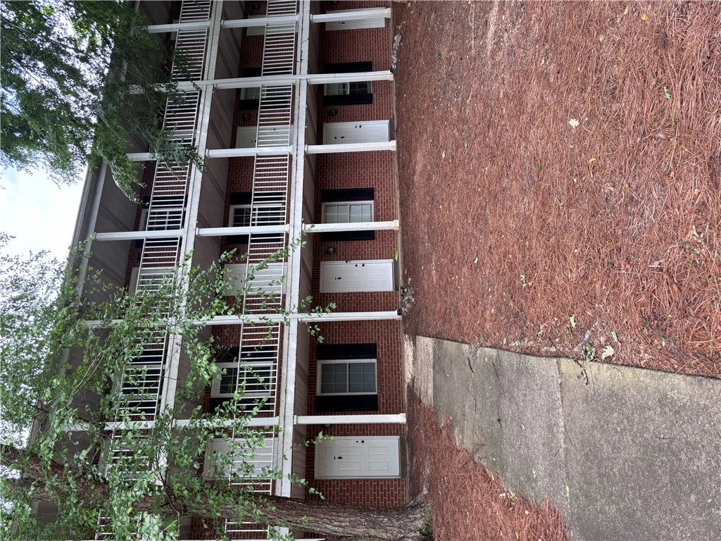 Multi-level brick facade with multiple units, each featuring an individual entry.