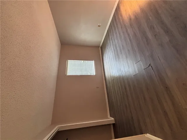 Well-lit room features durable wood flooring and ample space for comfortable living.